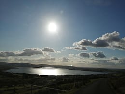 Beautiful landscape photograph of lake during a hiking trip in Ireland. The sun reflecting in the water 