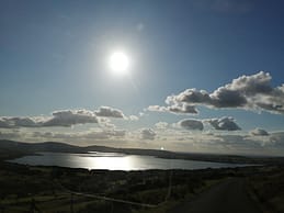 Beautiful landscape photograph of lake during a hiking trip in Ireland. The sun reflecting in the water 